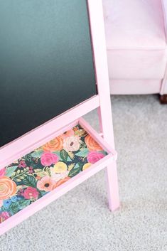 a pink desk with a flowered drawer underneath it and a white chair in the background