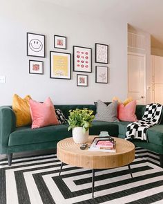 a living room with green couches and pictures on the wall above it's coffee table