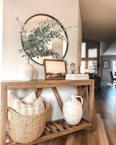 a living room with a wooden table and white vases on the shelf next to it