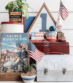 an assortment of books and other items on top of a wooden table next to a potted plant