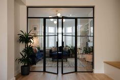 a living room filled with furniture and a large glass door that leads to a sitting area