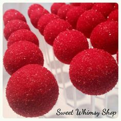 red cake pops are lined up on a white plate with the words sweet whimsy shop