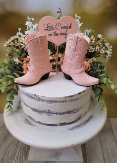 a wedding cake with pink cowboy boots on top