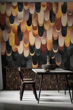 a table and two chairs in front of a wall with an abstract design on it