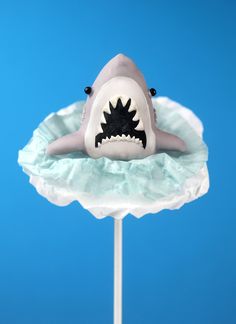 there is a cake shaped like a shark on top of a stick with its mouth open