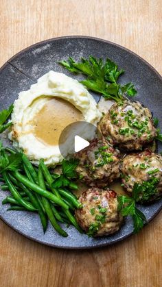 a plate with meatballs, mashed potatoes and green beans