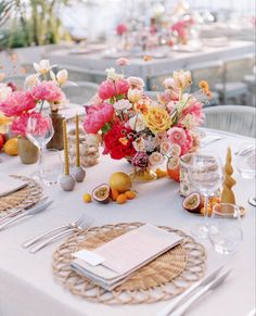 the table is set with flowers, candles and place settings for an elegant dinner party