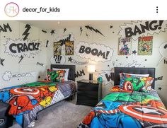 two beds in a room with comic themed wallpaper