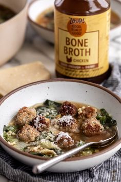 a bowl of soup with meatballs and broccoli next to a jar of bone broth