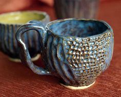 two ceramic cups sitting on top of a table