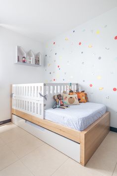 a child's room with a white crib and colorful wall decals on the walls