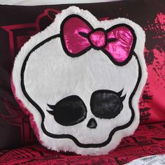 a skull pillow with a pink bow on it