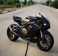 the motorcycle is parked on the side of the road in front of an empty street