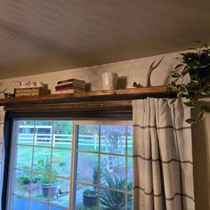 the window is open and there are plants in pots on top of the windowsill