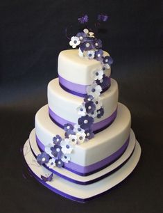 a wedding cake with purple and white flowers on it