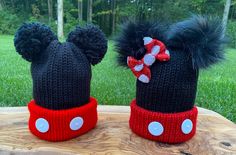 two knitted hats with ears and bows are sitting on a piece of wood in the grass