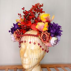 A stunning, statement floral headdress, with a variety of large purple, red, and yellow flowers and red foliage. A rigid band sits across the forehead with a row of delicate red beaded fringing. Made using artificial flowers and foliage, this piece will ensure you stand out from the crowd. At the back, there are two bands of elastic which secure the headdress and make it adjustable and comfortable to wear.  A standout piece that would be a fantastic addition to your festival wardrobe, fancy dres Red And Yellow Flowers, Floral Headdress, Red And Purple, Costume Hats, Fancy Dress Costumes, Beaded Fringe, Red And Yellow, Purple Floral, Headdress