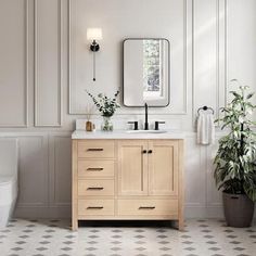 a white toilet sitting next to a wooden sink vanity in a bathroom under a mirror