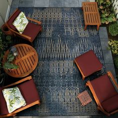 an overhead view of a patio with chairs, tables and rugs on the ground