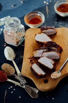 sliced pork on a cutting board with spices and seasonings