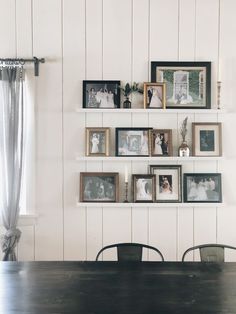 a dining room table with chairs and pictures on the wall