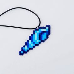 a necklace made out of blue beads on a black cord with a bead in the shape of an arrow