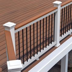 a white bench sitting on the side of a wooden deck next to a metal railing