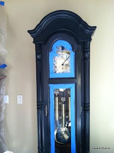 a grandfather clock with blue glass in front of it