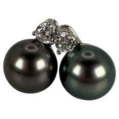 Stunning Tahitian pearl studs with 11mm pearls in 18KT white gold. The diamonds on top are approximately 0.30 carats each and the earrings have a stud closure. Pearls are natural not manmade or fabricated. GOLD: 18KT NATURAL DIAMOND(S) Clarity/Color: VS/G-H Cut: Round Brilliant Carat:0.60ct Grams:8.59 size: app.11mm pearls Item#: 310-00003 MPPE WHAT YOU GET AT STAMPAR JEWELERS: Stampar Jewelers, located in the heart of Jupiter, Florida, is a custom jewelry store and studio dedicated to providing Luxury Tahitian Pearl Earrings In White Gold, Tahitian Pearl Round Anniversary Earrings, Tahitian Pearl Earrings In White Gold For Anniversary, Luxury Tahitian Pearl Earrings For Anniversary, Jupiter Florida, Tahitian Pearls, Pearl Diamond, Pearl Studs, Tahiti