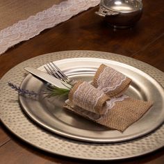 a silver plate with two napkins and a fork on it