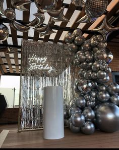 balloons and disco balls are hanging from the ceiling in this modern room with a happy birthday sign