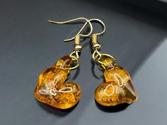 Gold lampwork glass heart earrings.  A pretty orange gold transparent glass with a twist of gold luster encased in each heart.  In a gold plated pair of earrings. Handmade in the flame and annealed over night, in my digitally controlled kiln, for durability and longevity.  These will arrive in a gift box and will be mailed in a bubble wrap envelope.  Created in my little studio here in the USA. Hearts Earrings, Autumn Jewelry, Glass Hearts, Pretty Orange, Fall Jewelry, Glass Heart, Orange Gold, Heart Earrings, Bubble Wrap