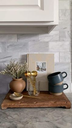 a wooden tray with vases and other items on it in front of a stove