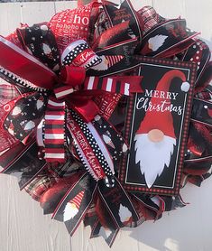 a christmas wreath with santa claus's face on it and red ribbon attached to the front