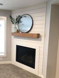 a fireplace with a mirror above it and a potted plant on the mantel