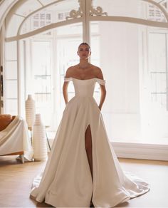 a woman in a white wedding dress posing for the camera