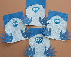 four handprinted pictures of blue and white characters on paper with hands in the air