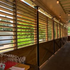 an outdoor restaurant with wooden slats on the outside wall and windows covered in blinds