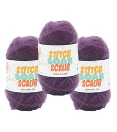 three balls of purple yarn sitting next to each other