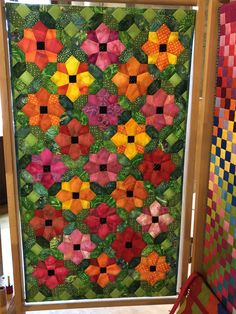 a colorful quilt hanging on the side of a door