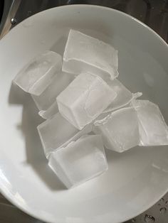 some ice cubes are in a white bowl