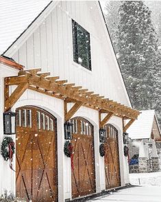 a white building with wooden doors and windows covered in snow