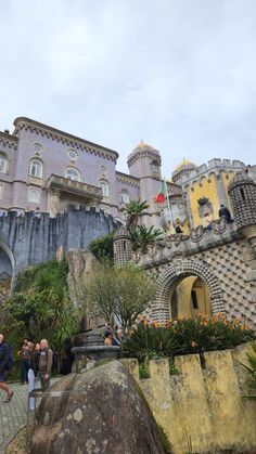 some people are standing in front of a castle