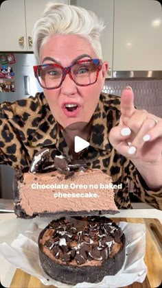 an older woman holding up a chocolate cake with the words chocolate oreo no baked cheesecake on it