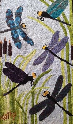 a quilt with dragonflies and flowers on it