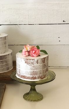 a white cake sitting on top of a table next to two rolls of toilet paper