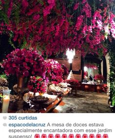 an outdoor dining area with flowers on the ceiling and candles lit up in front of it