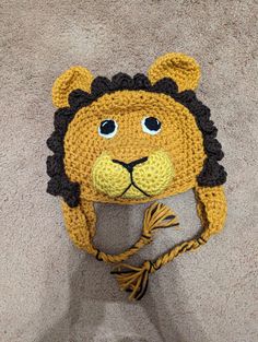 a crocheted hat with a lion face on it's head and ears