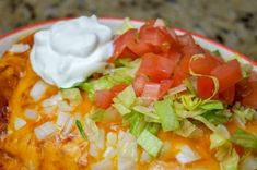 an enchilada is topped with sour cream and garnished with lettuce