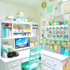 a white desk topped with a computer monitor next to a shelf filled with lots of books